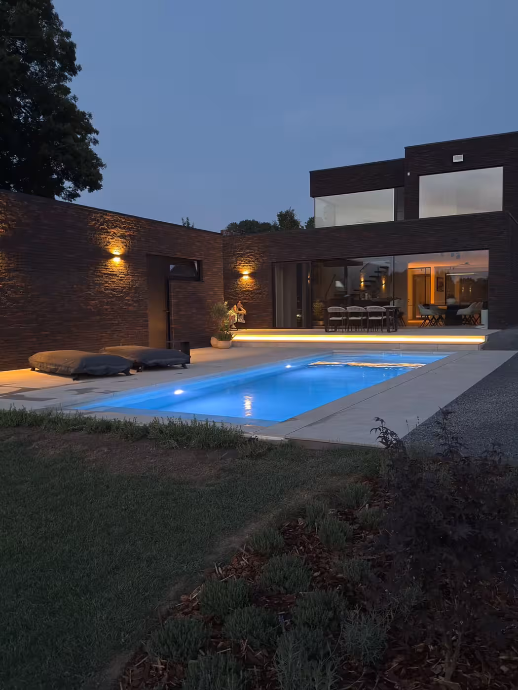 Bouwkundig zwembad 10 x 3 m met sfeerverlichting bij avond
